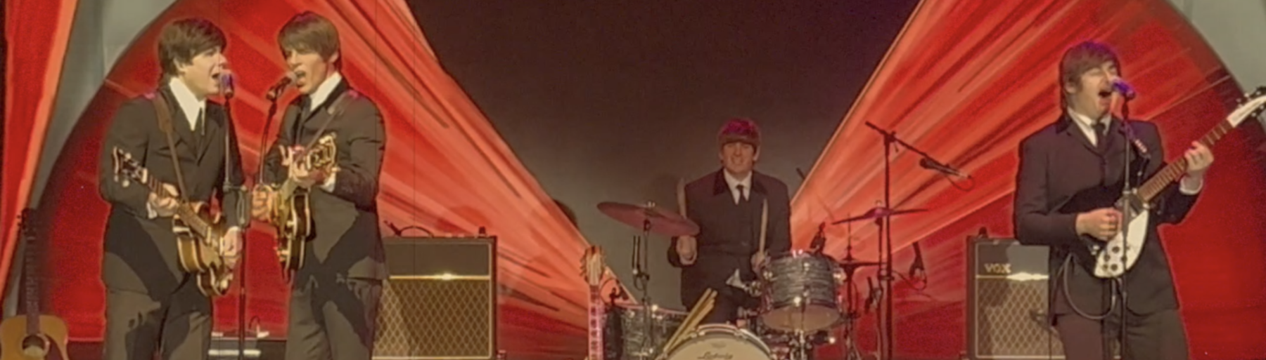 The Liverpool Beatles playing live in front of top a Hollywood Bowl backdrop